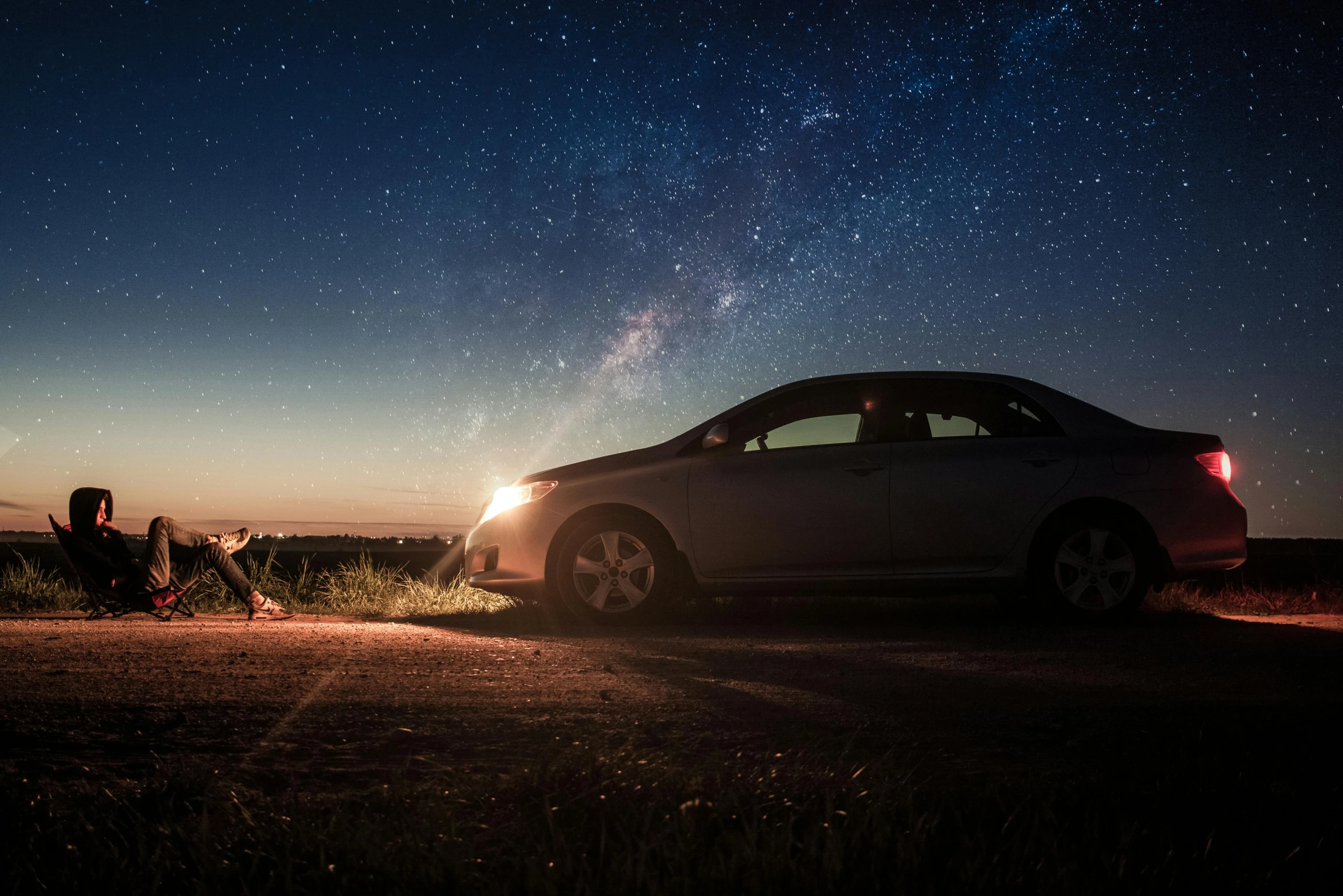 a car parked on the side of a road at night, by Matt Cavotta, pexels contest winner, magical realism, stargazer, sitting on the cosmic cloudscape, meteorites, dog watching the car