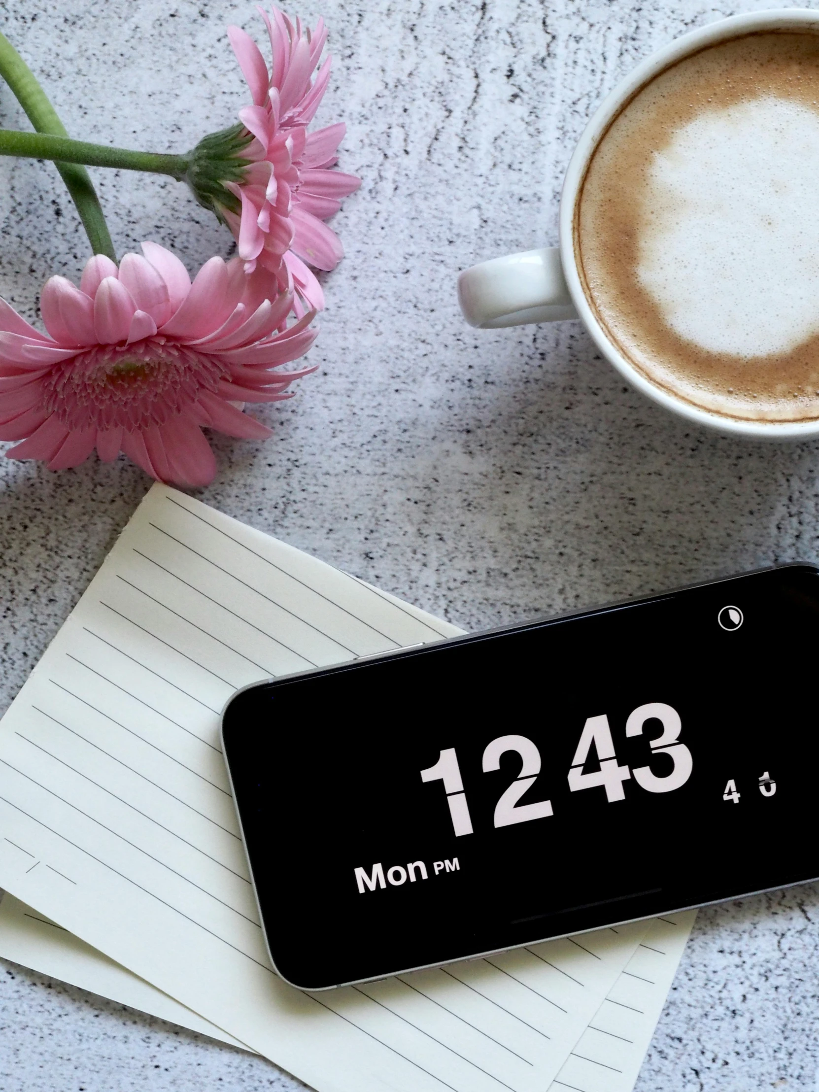 a cell phone sitting on top of a table next to a cup of coffee, clock, thumbnail, flowers, profile image