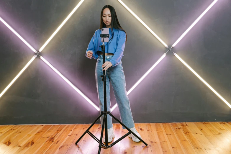 a woman standing in front of a camera on a tripod, by Robbie Trevino, live2d virtual youtuber model, rapping into microphone, casual pose, cinematic outfit photo