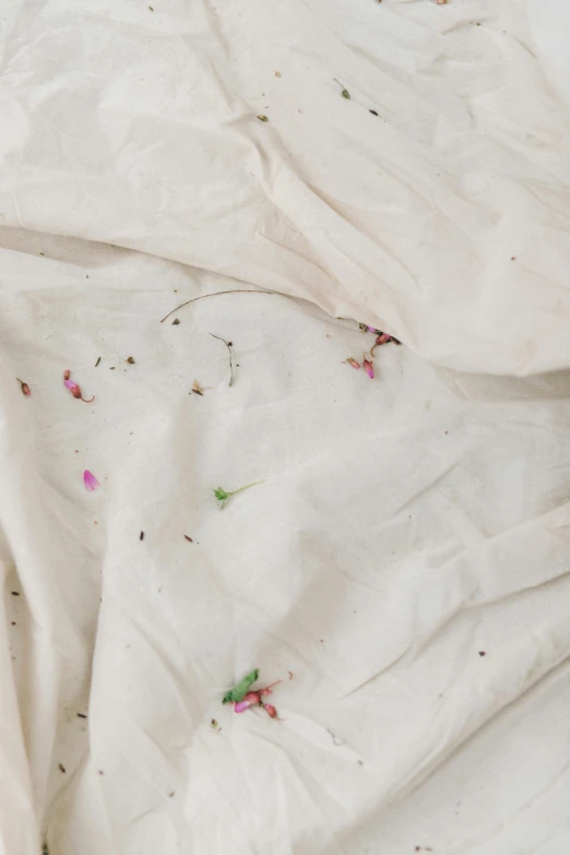 a bed with white sheets and pink flowers on it, by Rebecca Horn, trending on unsplash, renaissance, made of dried flowers, dirt stains, folds of fabric, background image