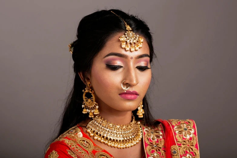 a woman dressed in a red and gold outfit, inspired by Saurabh Jethani, hurufiyya, professional makeup, thumbnail, jewelry lighting, hair jewellery