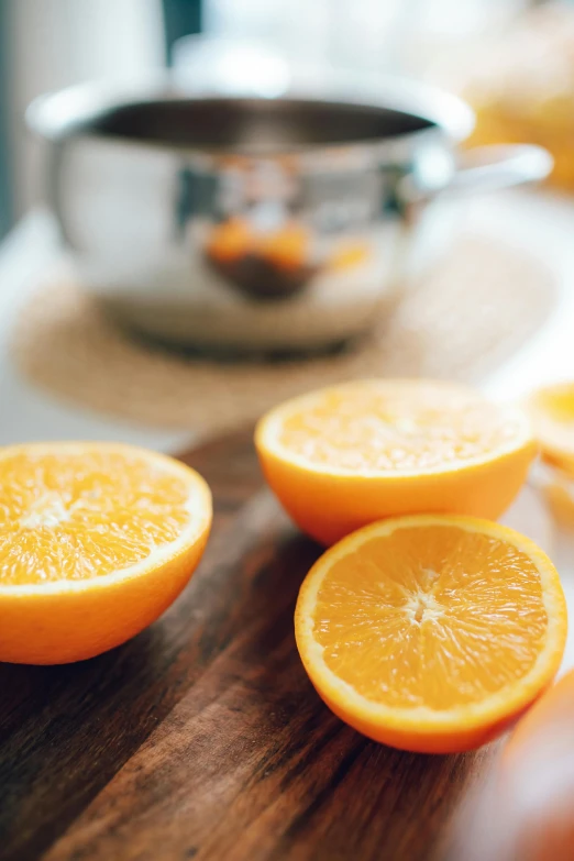 a wooden cutting board topped with sliced oranges, pexels, orange metal ears, morning detail, soup, reddit post