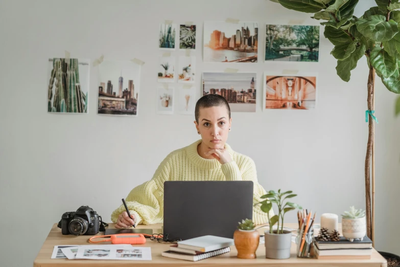 a woman sitting at a desk with a laptop, a picture, pexels contest winner, 9 9 designs, is looking at the camera, low quality photo, stacked image