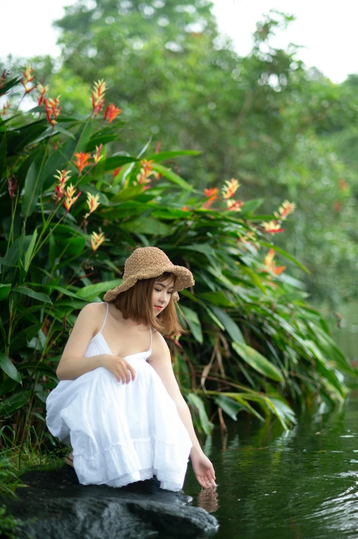 a woman sitting on a rock in a body of water, inspired by Fernando Amorsolo, unsplash, process art, lilies, with hat, lush environment, singapore