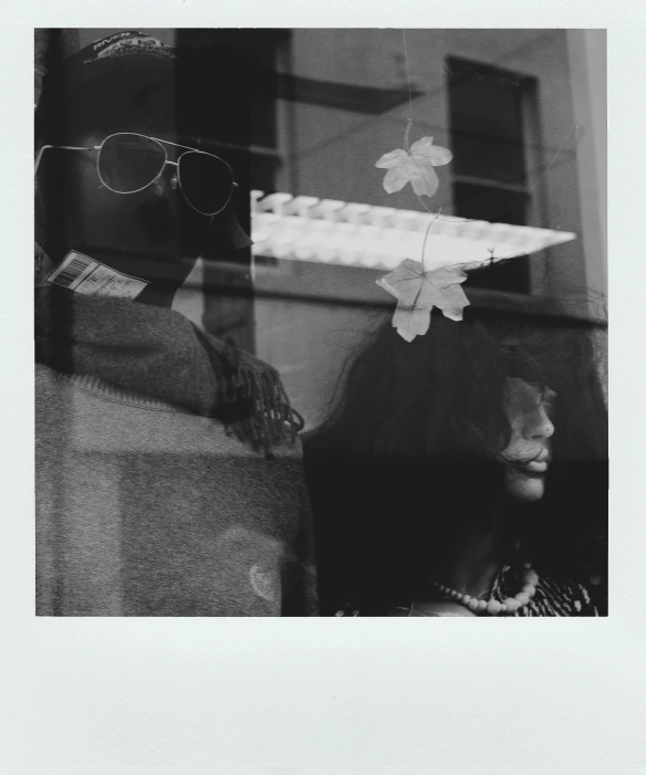 a black and white photo of a woman looking out a window, a black and white photo, new polaroid, man and woman, flower child, dark shades