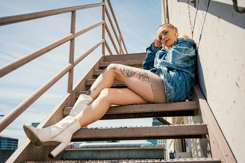 a woman sitting on a set of stairs talking on a cell phone, an album cover, inspired by Elsa Bleda, pexels contest winner, realism, denim hot-pants, lil peep, blue sky, platform boots