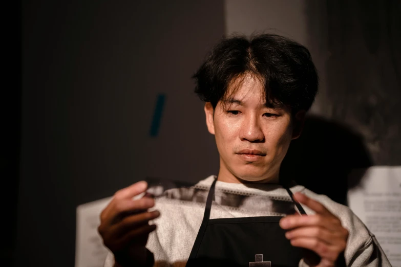 a close up of a person holding a plate of food, a portrait, shin hanga, aussie baristas, in dark room, cooking show, looking across the shoulder