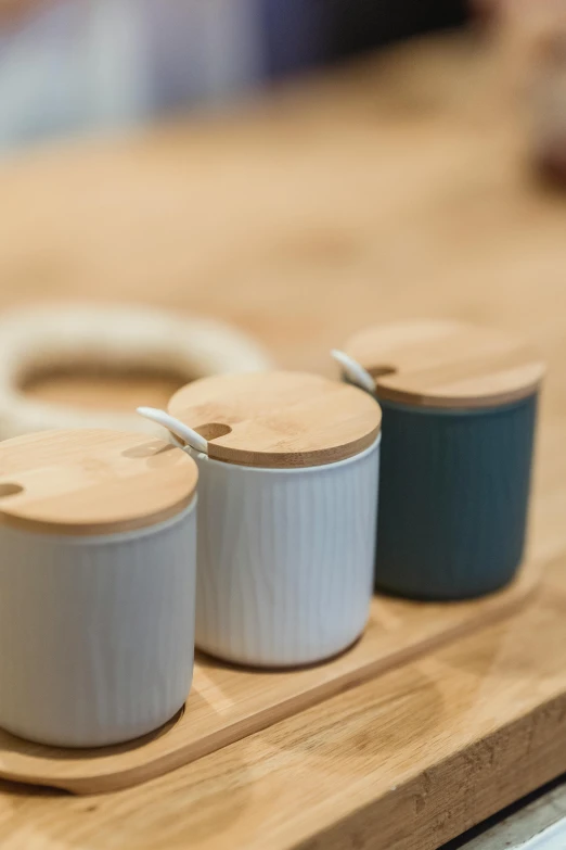 three pots sitting on top of a wooden cutting board, unsplash, blue soft details, product photograph, espoo, porcelain