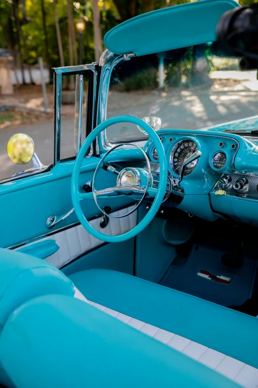 a close up of a car's dashboard and steering wheel, a colorized photo, by Tom Bonson, pexels contest winner, turquoise color scheme, 1957 chevrolet bel air, square, inside a grand