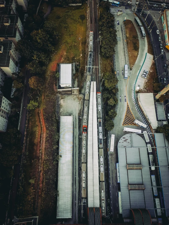 a train traveling through a city next to tall buildings, by Sam Black, pexels contest winner, bird\'s eye view, shot on iphone, high angle uhd 8 k, underground facility