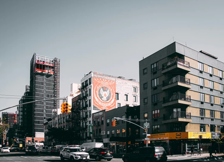 a city street filled with lots of traffic and tall buildings, a photo, pexels contest winner, harlem renaissance, advertising billboard, brutalist city architecture, overwatch building, 1 4 9 3