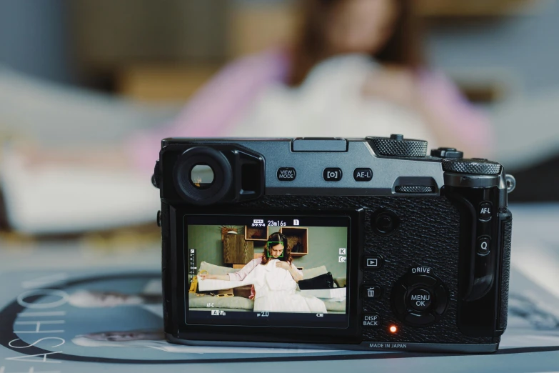 a camera that is sitting on a table, by Julia Pishtar, pexels contest winner, video art, fujifilm x - pro 2, two models in the frame, shot from the back, movie footage