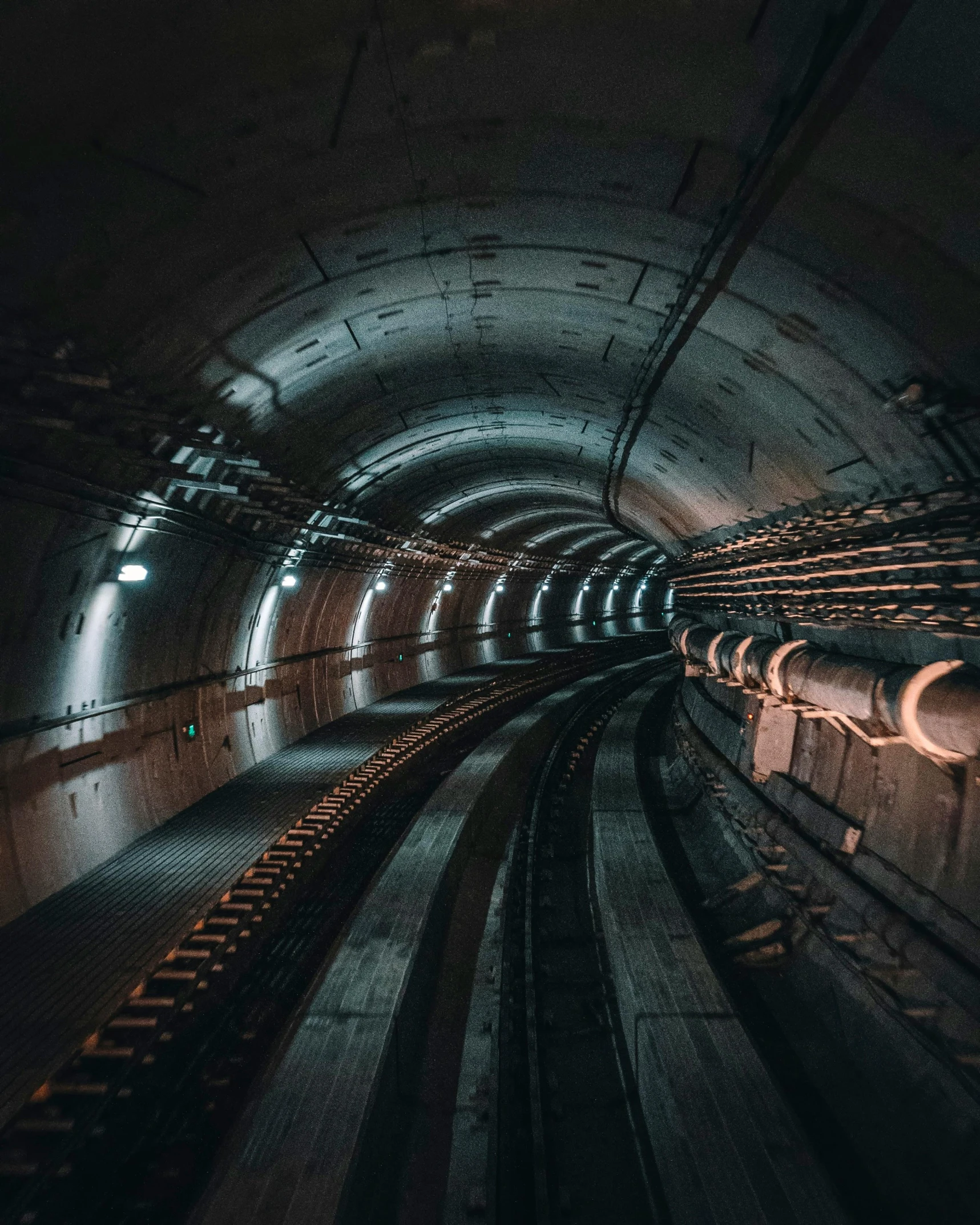 a train traveling through a tunnel at night, unsplash contest winner, metal towers and sewers, gray concrete, muted rainbow tubing, worksafe. instagram photo