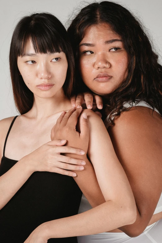 a couple of women standing next to each other, inspired by Wang Duo, trending on pexels, realism, tan skin, studio shoot, half asian, pale woman