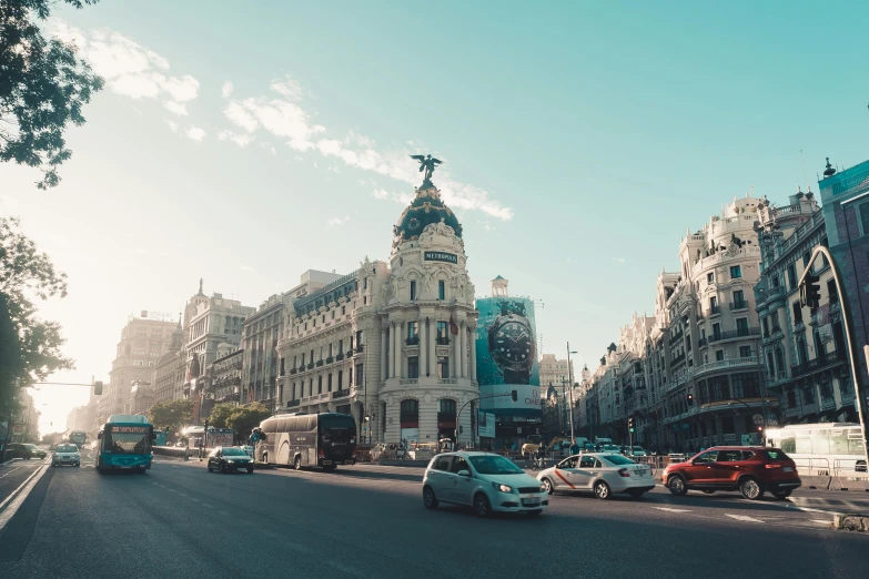 a city street filled with lots of traffic next to tall buildings, by Pablo Rey, pexels contest winner, neoclassicism, madrid, square, sunfaded, high resolution image