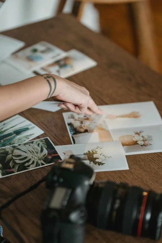 a person sitting at a table with a camera, a polaroid photo, trending on pexels, art photography, flowers, matte print, intricate image, botanical photo
