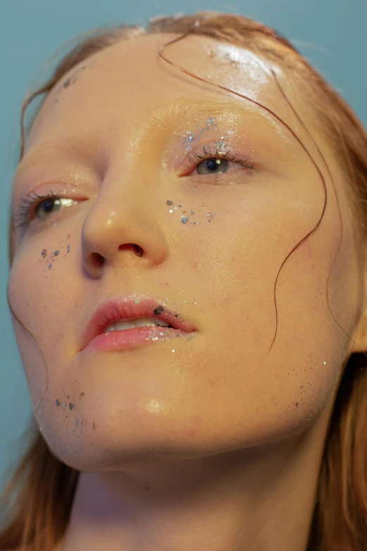 a close up of a woman with glitter on her face, an album cover, by Lee Gatch, reddit, hyperrealism, james jean and petra cortright, ginger hair with freckles, pale blue skin, still from a music video