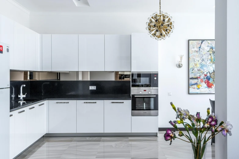 a kitchen with white cabinets and black counter tops, by Adam Marczyński, pexels contest winner, light and space, neo kyiv, panorama, fan favorite, flowers around