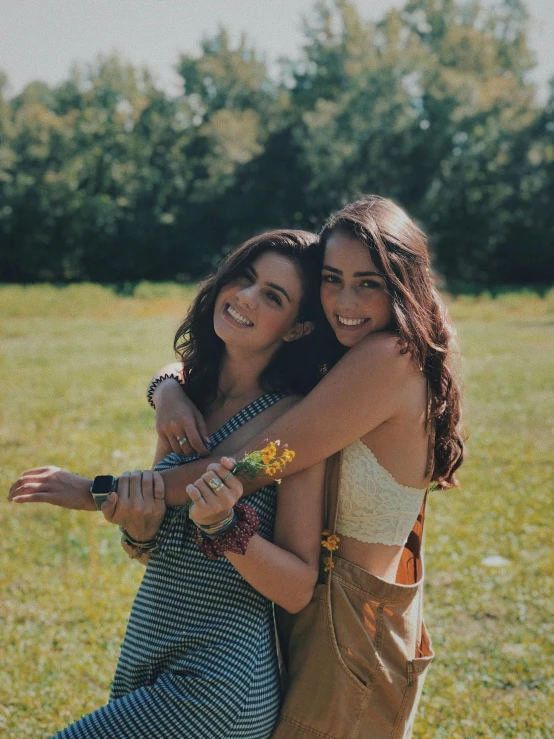 two women standing next to each other in a field, a picture, trending on unsplash, happening, brunettes, arm around her neck, smiling at camera, slide show