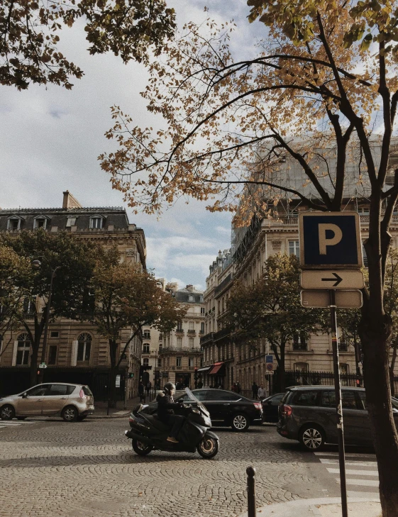 a street filled with lots of traffic next to tall buildings, a photo, paris school, muted fall colors, square, low quality photo, gif