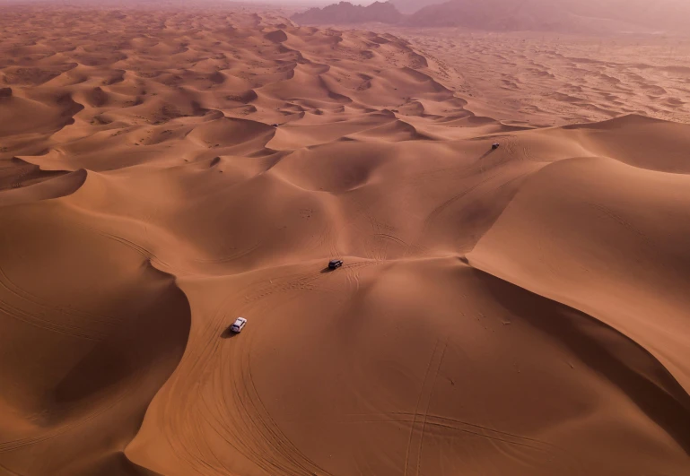 a car driving through the desert with mountains in the background, pexels contest winner, les nabis, aerial view top down, victorian arcs of sand, humans exploring, in the desert beside the gulf