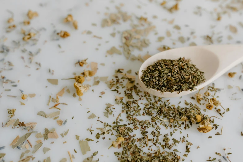 a spoon full of dried herbs on a table, by Emma Andijewska, trending on pexels, fan favorite, seafoam green, full body image, clean face and body skin