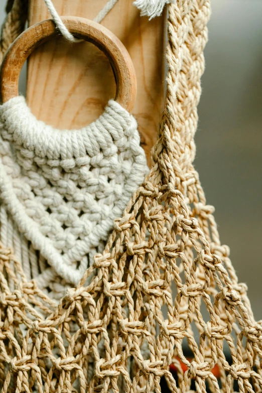 a close up of a bag with a wooden handle, inspired by Bernat Sanjuan, unsplash, macrame, half moon, 4l, dynamic closeup