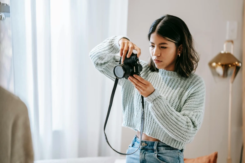a woman taking a picture of herself in a mirror, trending on pexels, visual art, wearing a cropped top, sweater, film camera, a young asian woman