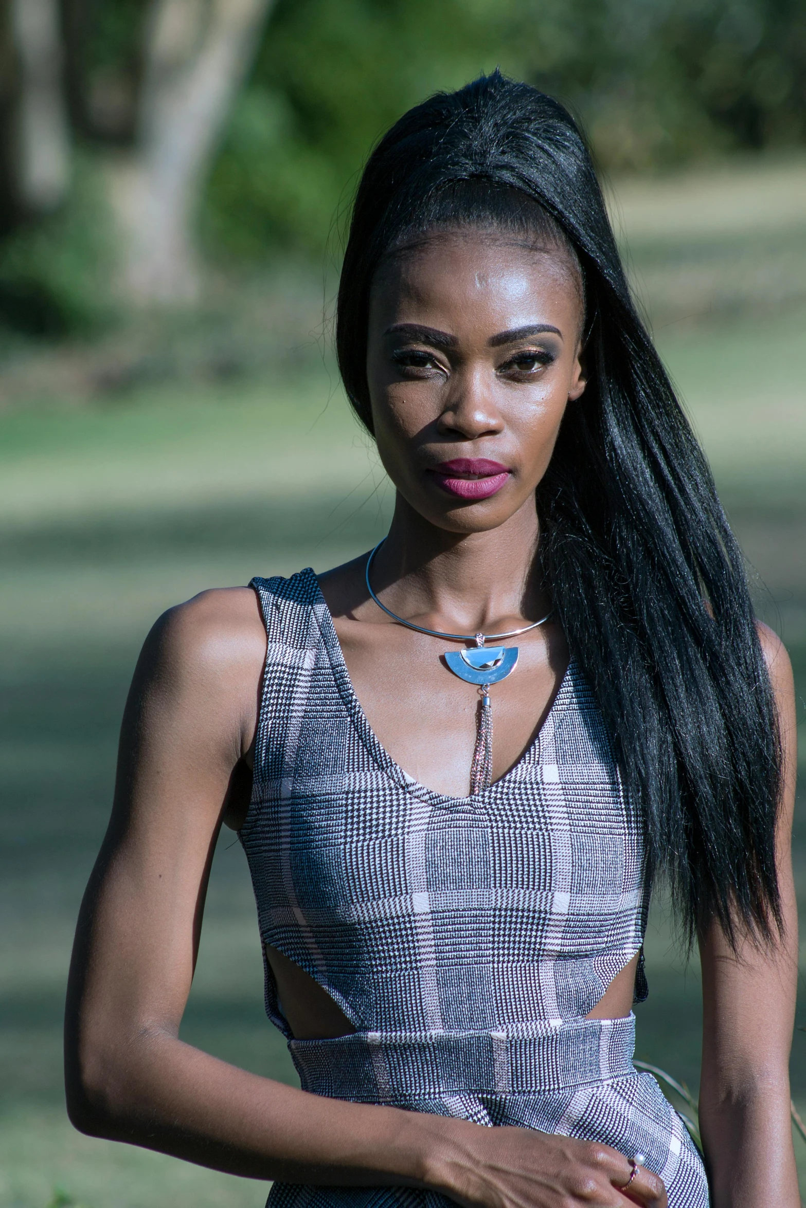 a woman standing in a park holding a frisbee, by Hubert van Ravesteyn, pexels contest winner, afrofuturism, wearing a vest top, hair jewellery, frown fashion model, tv show still