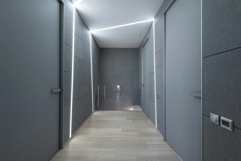 a long hallway with grey walls and wooden floors, a 3D render, inspired by Tadao Ando, unsplash contest winner, light and space, led light strips, opposite the lift-shaft, accent lighting : : peugot onyx, high - angle view