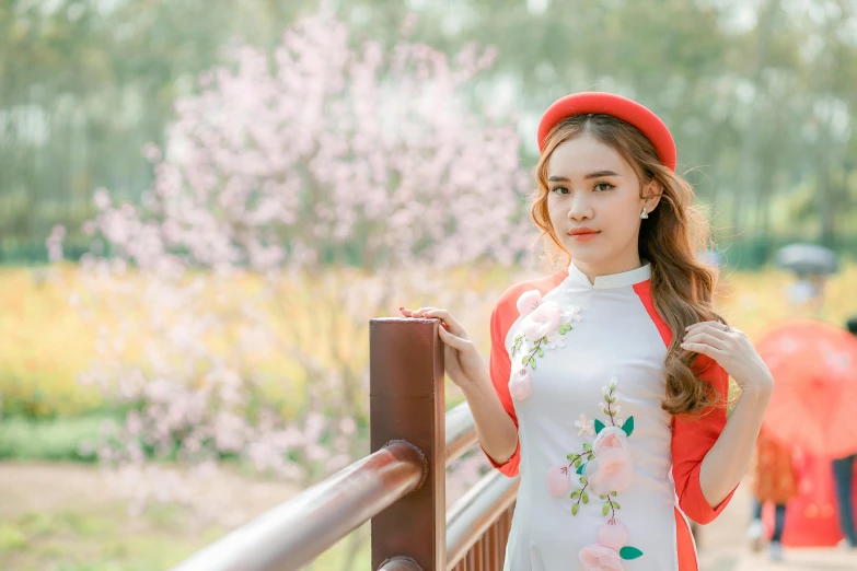 a woman in a white dress and a red hat, inspired by Cui Bai, trending on pexels, sakura season, ao dai, girl wearing uniform, (good looking )