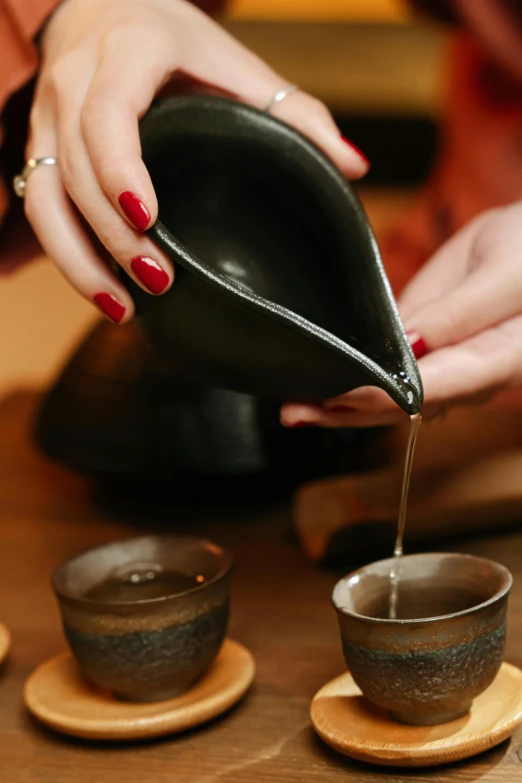 a person pouring tea into a cup on a table, inspired by Kanō Shōsenin, spa, square, thumbnail, upclose