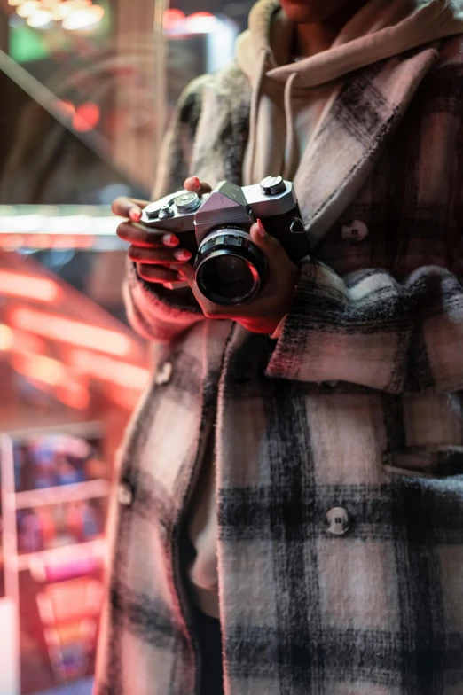 a man in a plaid coat holding a camera, pexels contest winner, brandon woelfel, movie still from bladerunner, today\'s featured photograph 4k, taken in the early 2020s