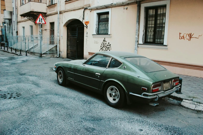 a green car parked in front of a building, inspired by Elsa Bleda, pexels contest winner, asphalt and metal, spitfire, mullet, giorgetto giugiaro