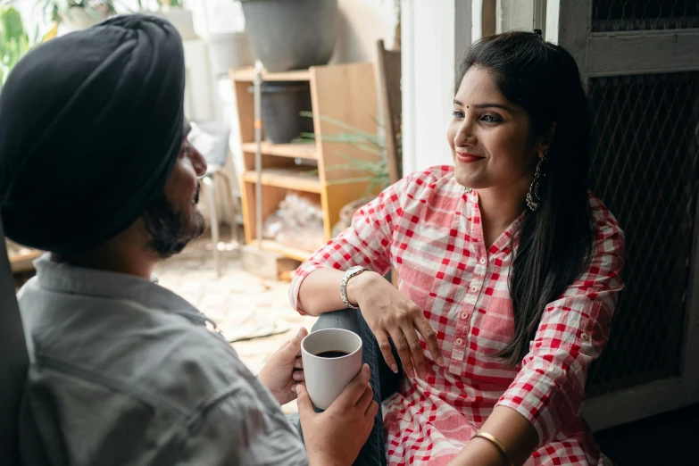 a man and a woman sitting next to each other, pexels contest winner, hurufiyya, next to a cup, indian, talking, realistic »