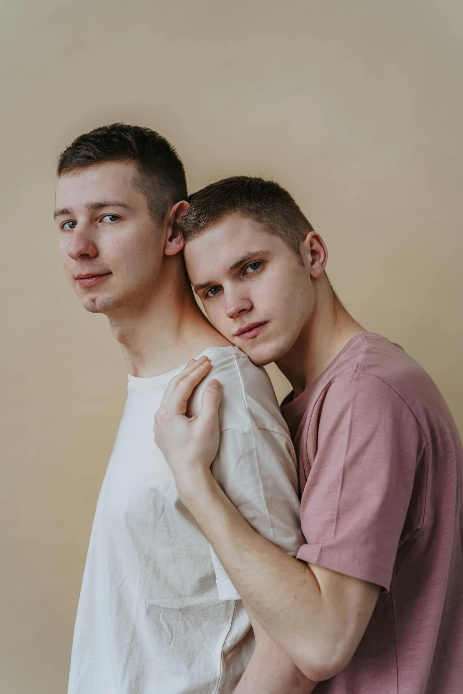a couple of young men standing next to each other, by Attila Meszlenyi, smooth pale skin, holding each other, trending photo