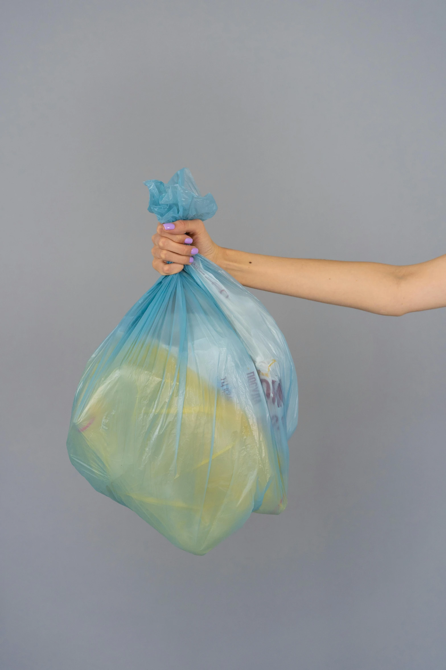 a person holding a bag of food in their hand, by Jessie Algie, plasticien, blue and yellow gradient, trash, without text, wash