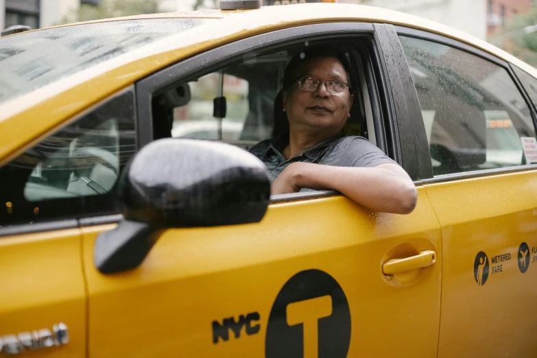 a woman sitting in the driver's seat of a taxi, by Michael Goldberg, humans of new york, asian man, profile image