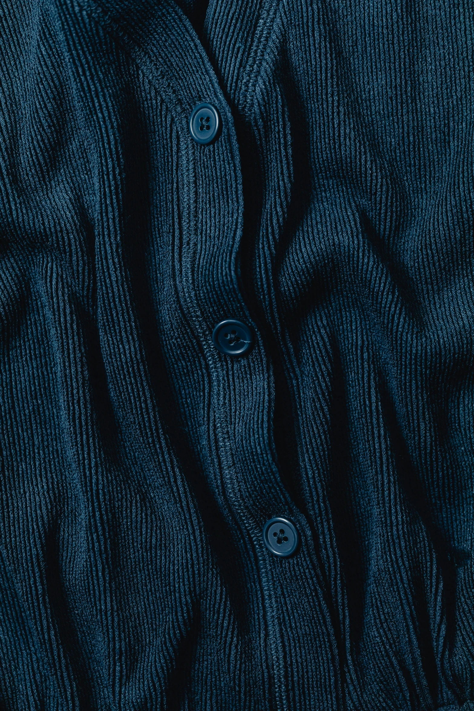 a close up of a blue sweater with buttons, trending on pexels, deep black, blue: 0.5, digitally remastered, cardigan