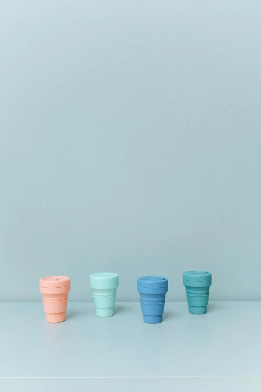 a row of cups sitting on top of a table, sherbert sky, silicone skin, kano), muted tonal colors