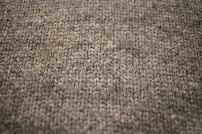 a black and white photo of a carpet, a stipple, inspired by Toss Woollaston, unsplash, realism, knitted mesh material, gradient brown to silver, old wool suit, shot with a canon 20mm lens