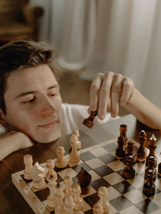 a man sitting at a table playing a game of chess, trending on unsplash, realism, discord profile picture, trending on mentalray, thoughtful pose, teenage boy