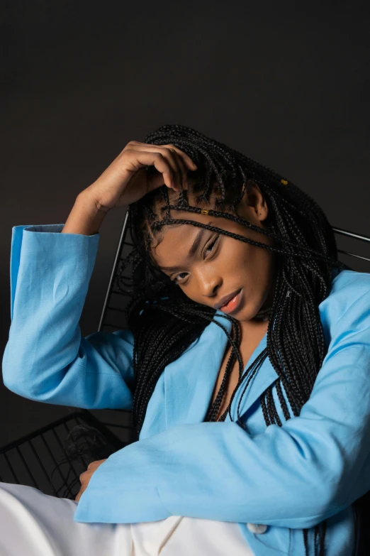 a woman with dreadlocks sitting in a chair, trending on pexels, double long braids blue, sza, non binary model, zendaya