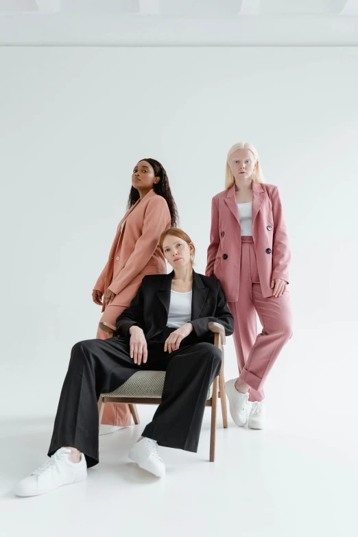 two women sitting on a chair next to each other, trending on pexels, three piece suit, wearing a track suit, three women, a full portrait of nordic female