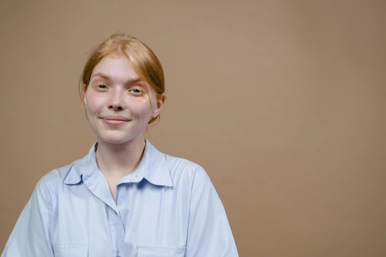 a close up of a person wearing a shirt, a character portrait, trending on unsplash, fair complexion, her skin is light brown, wearing a light blue shirt, studio portrait photo