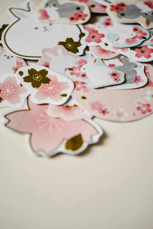 a bunch of stickers sitting on top of a table, inspired by Hasegawa Tōhaku, unsplash, pale pink and gold kimono, cherry blossom petals, diecut, close up details