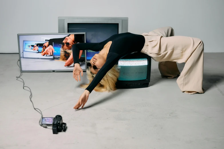 a woman laying on the floor in front of a television, a hologram, inspired by Sarah Lucas, unsplash, video art, jumping at the viewer, taken on a 2000s camera, motion capture system, bang olufsen