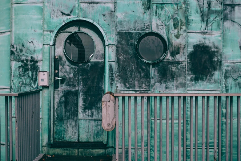 a close up of a door on a building, inspired by Elsa Bleda, pexels contest winner, postapocalyptic style, metalic green, rounded architecture, standing outside a house