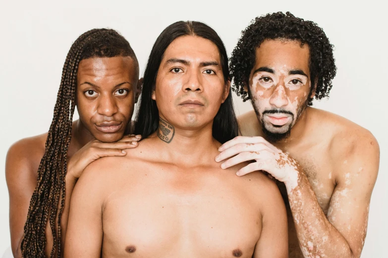 a group of men standing next to each other, an album cover, unsplash, antipodeans, brown skin like soil, three hairy neanderthal people, actors, sakuga gunplay