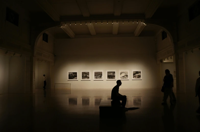 a man sitting on a bench in a dimly lit room, inspired by Fei Danxu, visual art, 4k museum photograph, shinichi fukuda, brooklyn museum, in an art gallery]